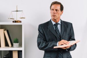 mature male lawyer holding law book standing courtroom